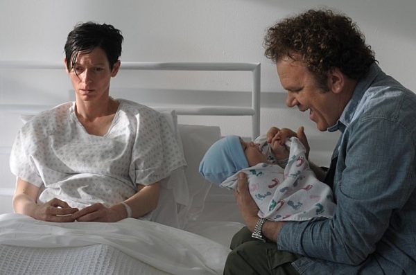 케빈을 낳은 후 침대에 앉아있는 에바. 에바의 남편이자 아이의 아빠인 프랭클린은 케빈을 안고 웃고 있다. 영화 ‘케빈에 대하여’(2011)의 한 장면. 제공=네이버영화