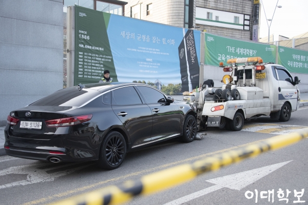 17일 사고차량이 본교 정문 앞에서 견인되고 있는 모습. 황보현 기자 bohyunhwang@ewhain.net