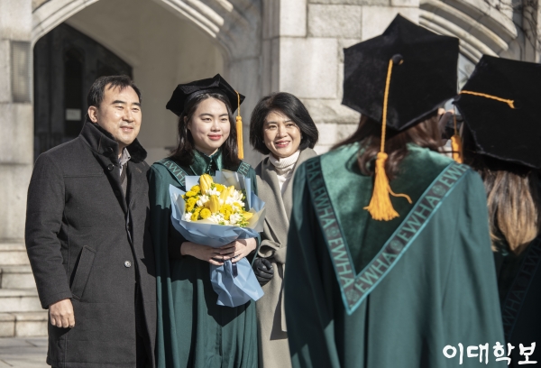 대강당 앞에서 꽃다발을 들고 부모님과 함께 사진을 촬영하는 졸업생 황보현 기자 bohyunhwang@ewhain.net
