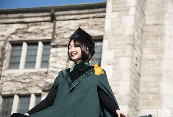 새로운 학위복을 펼쳐 보이는 졸업생 황보현 bohyunhwang@ewhain.net
