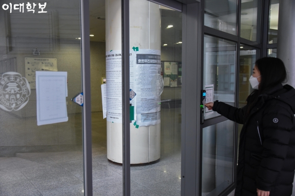 기자가 통제된 이화.포스코관의 출입을 위해 학생증을 카드리더기에 인식하고 있다.김서영 기자 toki987@ewhain.net