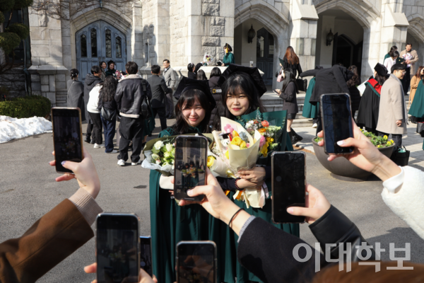 졸업생 김채원(경영•24년졸)씨(왼쪽)와 양수빈(교육•24년졸)씨의 졸업을 축하하며 많은 친구들이 기념사진을 남겨주고 있다. <strong>변하영 사진기자