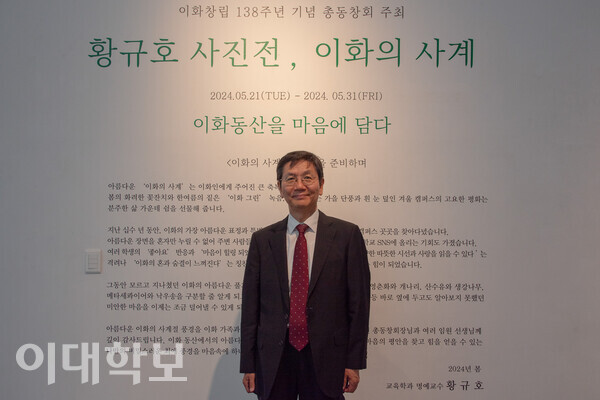 자신의 사진전을 소개하는 글이 적힌 벽면 앞에 서 있는 황규호 명예교수. <strong>강연수 사진기자