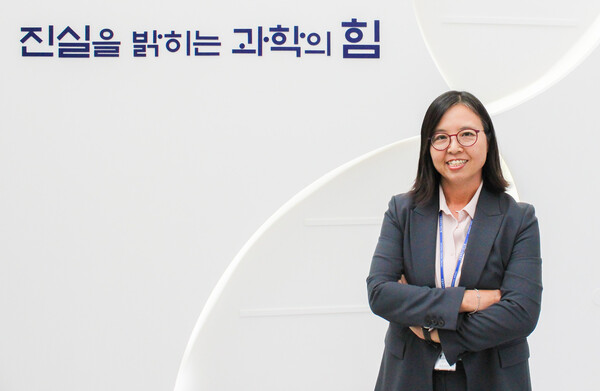 국과수의 슬로건 '진실을 밝히는 과학의 힘' 앞에서 환하게 웃는 김은미 전 법과학부장. 제공=김은미 박사