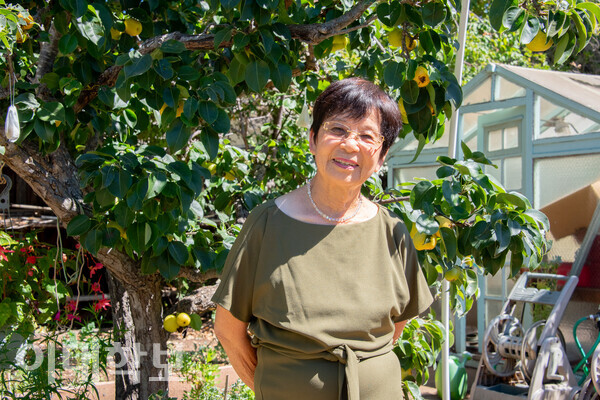 초록빛이 가득한 정원에서 배나무를 배경으로 카메라를 바라보고 있는 강희식씨. 강씨는 “이화인만큼 가장 끈끈하게 모이는 경우가 없다”며 이화에 대한 애정을 드러냈다. <strong> 안정연 사진기자