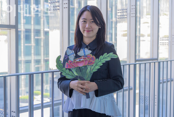 나난 강 작가의 '롱롱타임플라워(Long long time flower)' 초충도 에디션을 들고 카메라를 응시하고 있는 김예지씨. 김예지씨는 직접 기획한 전시로 가족들에게 위로를 전할 수 있던 경험에 대해 얘기하며 “예술이 사람을 치유하는 힘이 있다는 걸 다시 한 번 느꼈다”고 말했다. <strong>남현지 사진기자