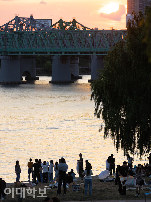 길서연씨는 철교 위를 지나는 열차와 노을을 바라봤다. 산호빛 하늘 아래, 철길을 따라 달리는 열차의 소리를 들으며 분주했던 마음을 떠나보낸다. <strong> 변하영 사진기자