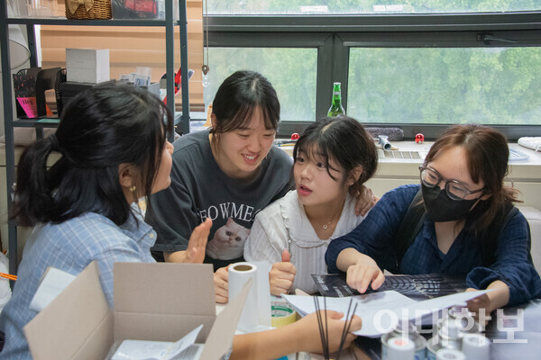 학문관 502-3호에 위치한 동방에서 포스터를 보며 이야기 나누고 있는 이뮤 부원들의 모습. <strong> 강연수 사진기자