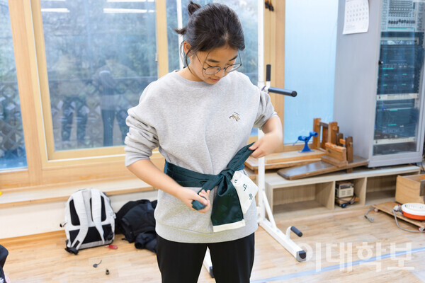 다목적 비단주머니 ‘궁대’를 착용 중인 심고은(교공·22)씨의 모습. 주로 허리에 찬 후 화살을 끼워 사용한다. 천화 부원들끼리 이화그린색 원단을 구입해 ‘천화’와 부원의 이름을 자수 넣어 맞춤 제작한 것이다. <strong> 남현지 사진기자