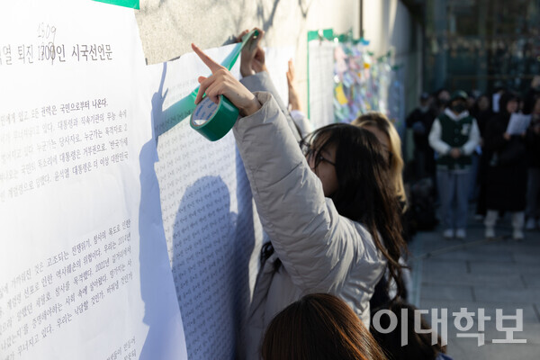 기자회견을 마무리하며 정문 앞 벽에 시국선언문을 부착하는 모습. <strong> 안정연 사진기자