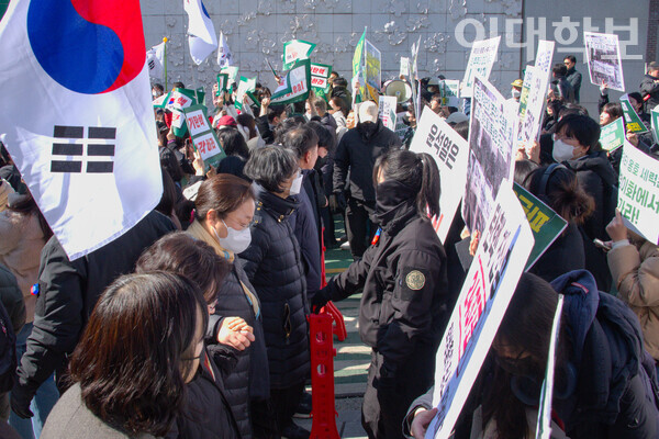 정문의 탄핵 찬반 대치현장에서 안선희 교목실장과 교직원들이 스크럼을 짜 양측의 충돌을 방지하고 있는 모습. 진유경 사진기자