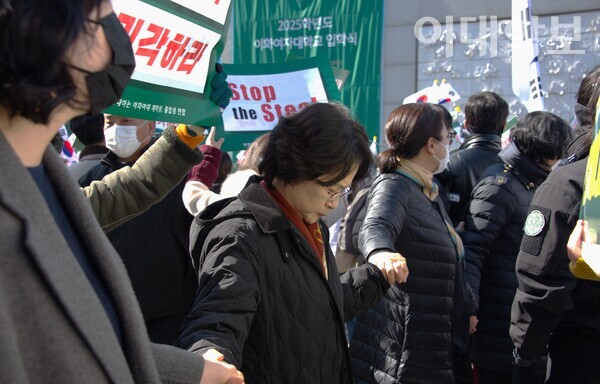 정문의 탄핵 찬반 대치현장에서 안선희 교목실장과 교직원들이 스크럼을 짜 양측의 충돌을 방지하고 있는 모습. 진유경 사진기자