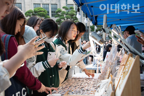 대동제 이튿날인 지난 9일 오후 5시부터 운영된 플리마켓에 이화인이 참여하여 신중히 악세사리를 고르고 있다. 출처=이대학보DB