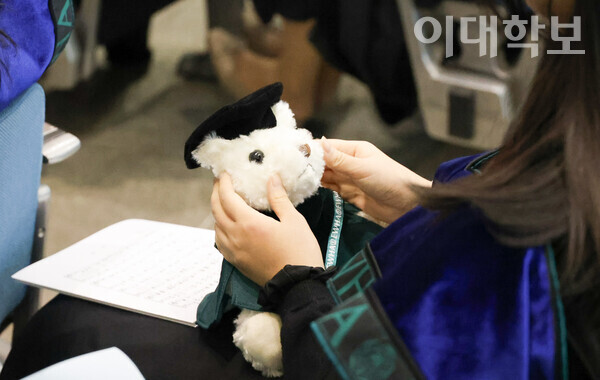 학위복을 입은 학사모 곰돌이를 쓰다듬고 있는 이화인의 모습. <strong>채의정 사진기자