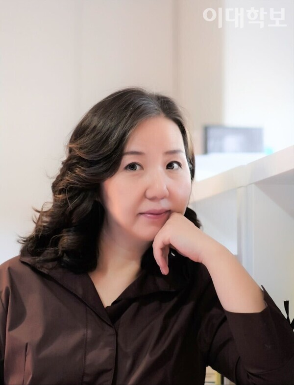 책장에 기대어 웃고 있는 이수정 작가. 제공=이수정씨