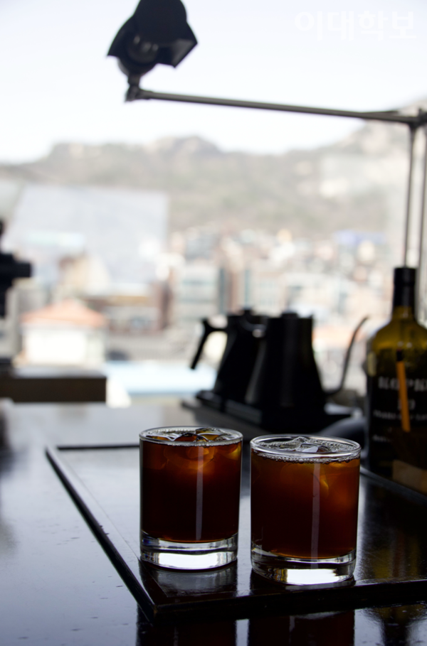 서촌의 ‘인왕산 대충유원지’ 카페의 커피와 그 뒤로 펼쳐친 인왕산 풍경. <strong>채의정 사진기자