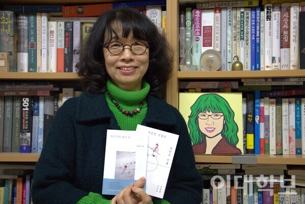정끝별 교수가 그의 저서 ‘시 쓰기 딱 좋은 날’과 ‘깨끗한 거절은 절반의 선물’을 들어보였다. 동시에 제자가 그려준 그림 속 자신과 비슷한 미소를 짓고 있다. 진유경 사진기자
