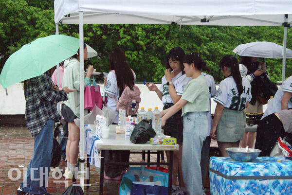 우산을 쓰고 방문한 이화인들로 가득 찬 일본인유학생회의 타코야끼 부스의 모습. <strong>정영인 사진기자