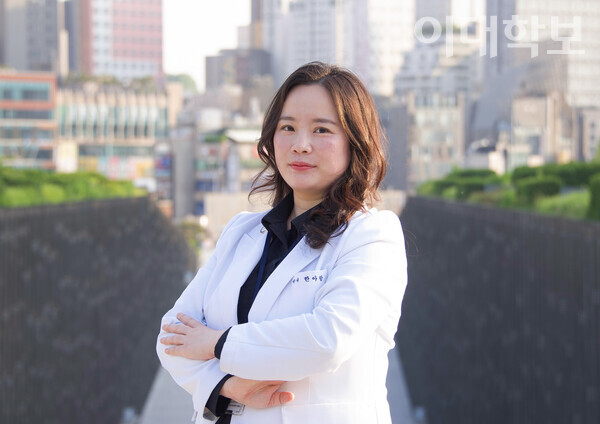 강동경희대병원 약제실 조제팀에서 근무 중인 한아람(약학·15년졸)씨가 ECC를 배경으로 미소짓고 있다. <strong>채의정 사진기자