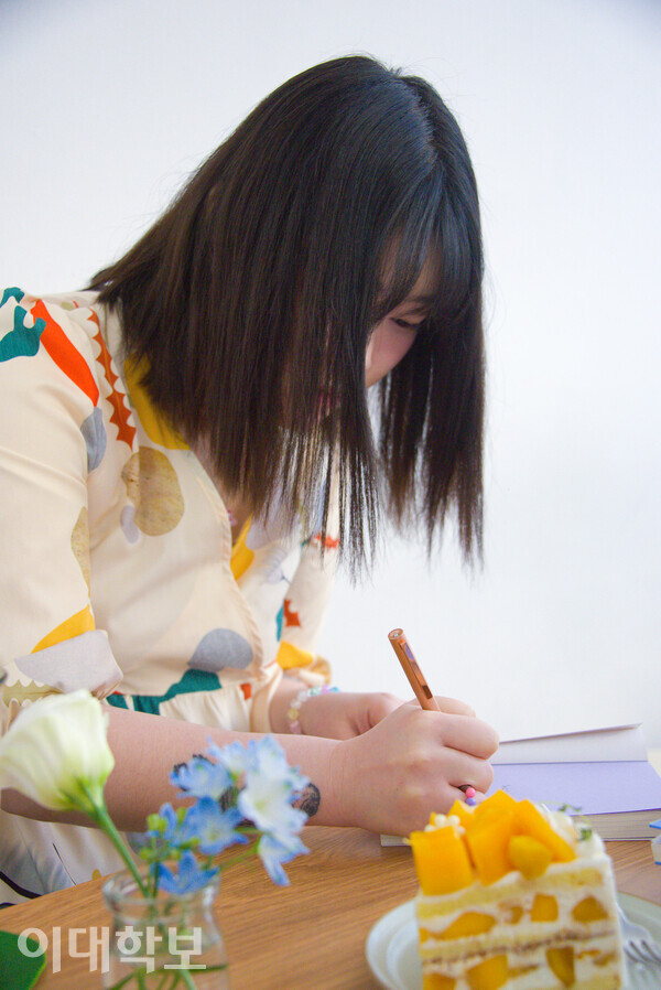 ‘무한히 터지는 기포를 담아’라는 문구와 함께 싸인을 하고 있는 고선경 시인의 모습. <strong>진유경 사진기자