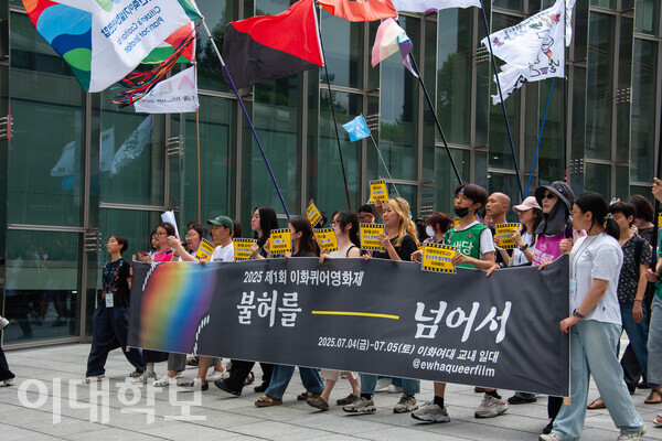 제1회 이화퀴어영화제 개막식 참가자들이 플래카드를 들고 ECC 밸리를 행진하고 있다. 진유경 사진기자
