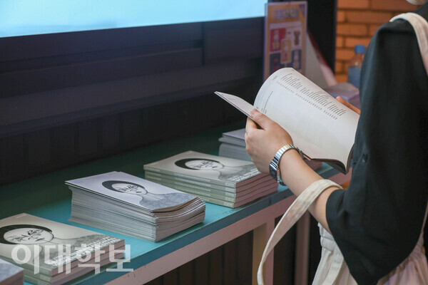 서울국제여성영화제 참여자가 행사장 내부에 놓인 영화제 안내 책자를 읽고 있다. 진유경 사진기자