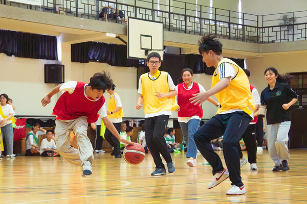 참가자들이 Inclusive Zone 농구를 하고 있다. 골대에 공을 넣기 위해 빨강 팀의 선수가 열심히 드리블을 하고, 노랑 팀은 수비하기 위해 달려가고 있다. 진유경 사진기자