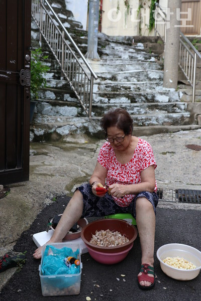 박영림(83)씨가 골목에 앉아 마늘을 손질하고 있다. <strong>채의정 사진기자