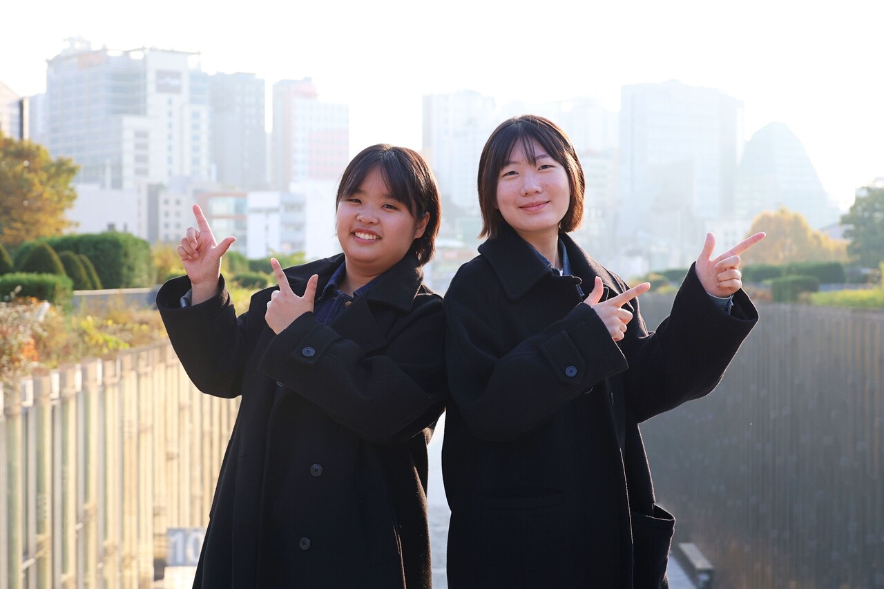 ECC 앞에서 ‘스텝업’의 공식 포즈를 선보이며 미소짓는 반지민 총학생회장(왼쪽)과 송수진 부총학생회장의 모습. 정영인 사진기자