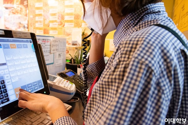 전화 주문을 받고 있는 아르바이트생의 모습.  출처=이대학보 DB