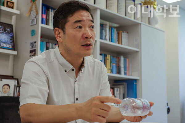 생수병을 든 김우재 교수가 반응성이 낮은 PE와 PP의 반응성을 높이는 ‘열산화 전처리’에 대해 설명하고 있다. 김 교수는 생수병을 사용해 공정 과정을 실험한 바 있다. <storng>윤다영 사진기자</stong>